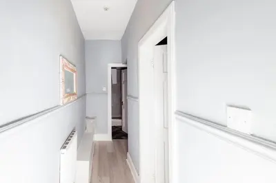a hallway with white walls and a white staircase at Central Apartment by the Meadows 9 in Edinburgh
