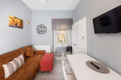 a living room with a couch and a tv at Central Apartment by the Meadows 9 in Edinburgh