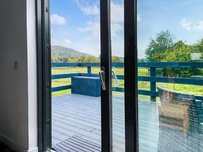 a sliding glass door with a view of the water at Riverview Lodge in Acharra