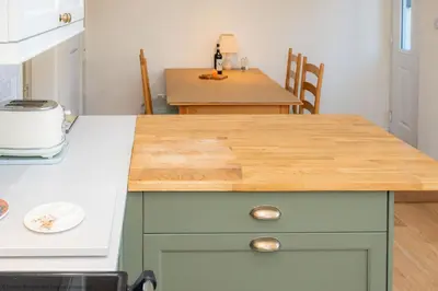 a kitchen with a counter top and a table at Craignair in Castle Douglas