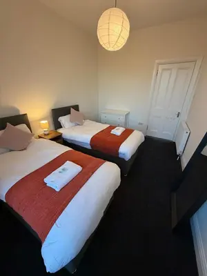 a hotel room with two beds and a chandelier at Spacious Tenement with free parking in Glasgow