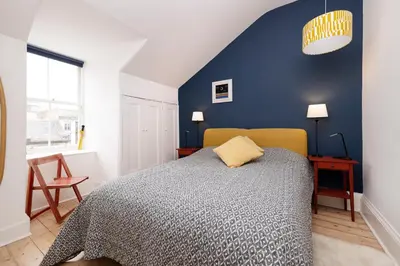 a bedroom with a bed and a blue wall at Chic 1-Bedroom Apartment in Edinburgh New Town in Edinburgh