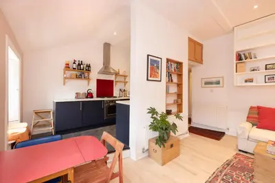 a kitchen and living room with a red table in a room at Chic 1-Bedroom Apartment in Edinburgh New Town in Edinburgh