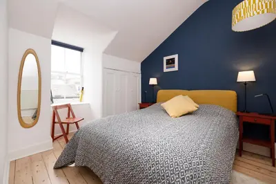 a bedroom with a bed and a blue wall at Chic 1-Bedroom Apartment in Edinburgh New Town in Edinburgh