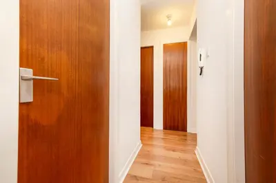 a hallway with a wooden door and wooden floors at Edinburgh Morningside 2-Bedroom Apartment - Ground Floor in Edinburgh