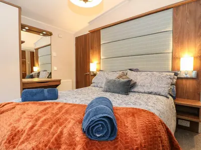 a bedroom with a large bed with blue pillows at Loch Lomond Holiday home in Arrochar