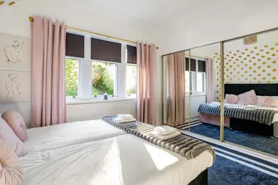 a bedroom with a bed and a mirror at Edwardian Manor hot tub & Pool in Glasgow, Gated in Giffnock