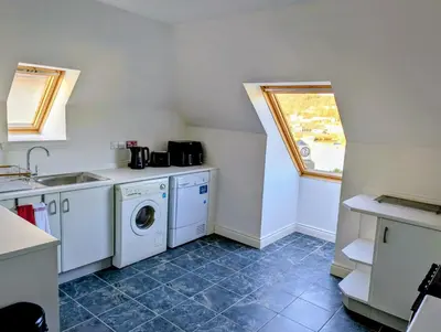 a kitchen with a sink and a washing machine at Littlebay Penthouse in Oban