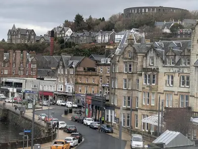 a city with cars parked on a street with buildings at Littlebay Penthouse in Oban