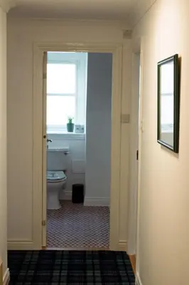 a bathroom with a toilet and a window at Littlebay Penthouse in Oban