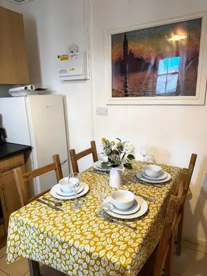a dining room table with a yellow and white table cloth at Entire 1 bedroom in VAUXHALL Central London Zone 1 in Moffat
