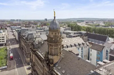 a building with a tower on top of a city at Cozy Room in Glasgow in Glasgow