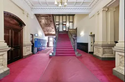 a hallway with red carpeted stairs in a building at Cozy Room in Glasgow in Glasgow