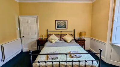 a bedroom with a bed with yellow walls at Estate Getaway at Powis House Estate in Stirling