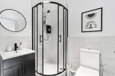 a bathroom with a shower and a toilet and a sink at Newly Renovated 1BR Steps from Hove Beach in Moffat