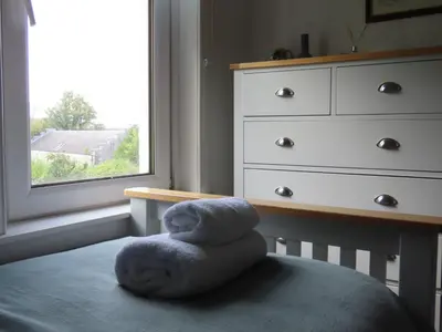 a stuffed animal sitting on a bed next to a window at Inveree in Oban