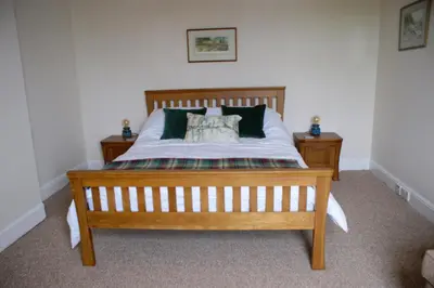 a bedroom with a wooden bed with two night stands at Inveree in Oban