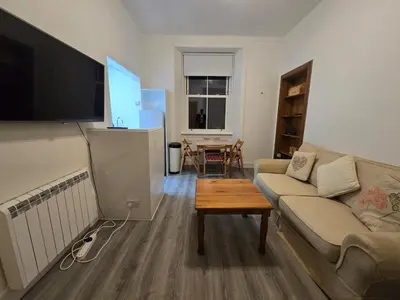 a living room with a couch and a table at Comfy Semi-Central Stay near Entertainment Park in Edinburgh