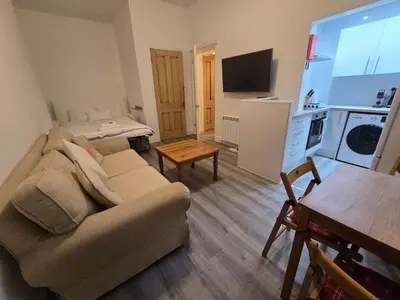 a living room with a couch and a table at Comfy Semi-Central Stay near Entertainment Park in Edinburgh