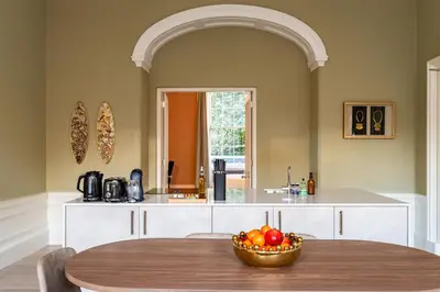 a kitchen with a table with a bowl of fruit at Dragon Suites Luxury Apartments at Rutland Square in Edinburgh
