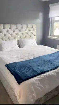 a white bed with a blue blanket on it at 4 Bed Detached Home Perfect for Families & Groups in Glasgow