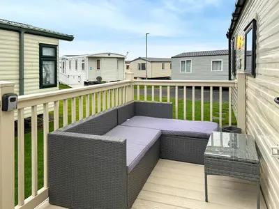 a patio with a bench and a table on a balcony at Ali B's Craig Tara in Ayr