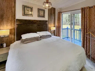 a bedroom with a large white bed and a window at Woodland View in Auchterarder