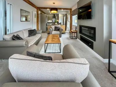 a living room with two couches and a fireplace at Woodland View in Auchterarder