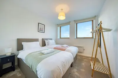 a bedroom with two beds and a tripod at Modern Luxe Apartment in Glasgow City Centre in Glasgow
