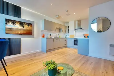 a large kitchen with blue and white walls and wooden floors at Modern Luxe Apartment in Glasgow City Centre in Glasgow