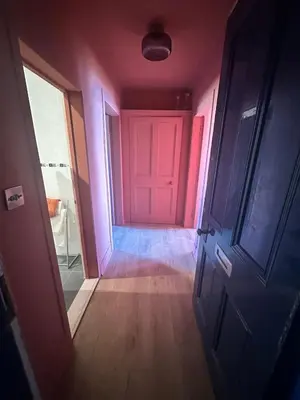 a hallway with a pink door in a room at The Skipper's Rest in Millport
