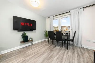 a dining room with a table and chairs and a tv at Urban Elegance - Spacious 5-Bed Home in Glasgow in Glasgow