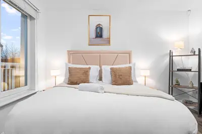 a bedroom with a large white bed with a window at Urban Elegance - Spacious 5-Bed Home in Glasgow in Glasgow