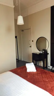 a bedroom with a bed with a mirror and a desk at The Graeme Hotel in Falkirk