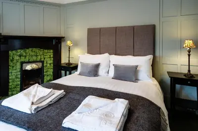 a bedroom with a large bed with two towels on it at Glenbruar House in Crianlarich