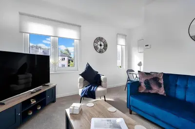 a living room with a blue couch and a tv at Fraser Apartment- 2 Bedrooms Inverleith, Edinburgh in Edinburgh