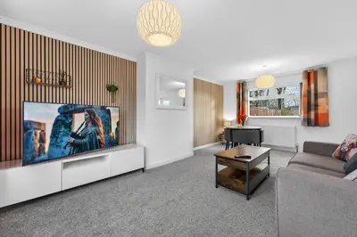 a living room with a couch and a flat screen tv at The Hide - Suburban Terraced Home in Horse Isle