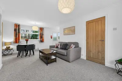 a living room with a couch and a table at The Hide - Suburban Terraced Home in Horse Isle