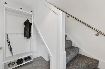 a staircase with white walls and a white stair case at The Hide - Suburban Terraced Home in Horse Isle