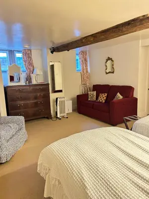 a bedroom with a bed and a couch and a dresser at Garden flat at Broomfield in Moffat