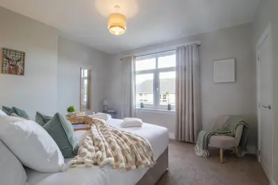 a bedroom with a bed and a window at Pinkerton House - 3 bed Rutherglen in Glasgow