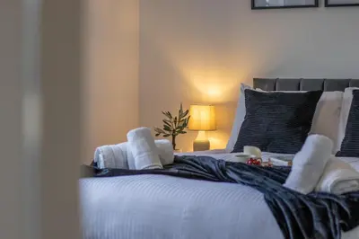a bedroom with a bed with white towels on it at The Wishy - 2 Bedroom Flat in Newmains in Newmains