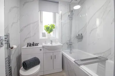 a bathroom with a toilet and a sink and a tub at The Wishy - 2 Bedroom Flat in Newmains in Newmains