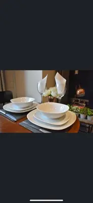 a table with two white plates and glasses on it at Morden 2 bedroom in Edinburgh City in Edinburgh