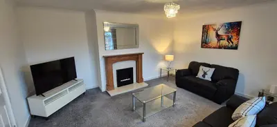 a living room with a couch and a fireplace at Stirling apartment - free parking in Stirling