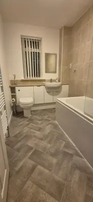 a bathroom with a tub and a toilet and a sink at Stirling apartment - free parking in Stirling