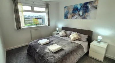 a bedroom with a bed with two pillows on it at Stirling apartment - free parking in Stirling