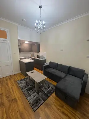 a living room with a couch and a table at Glasgow - Cosy 1 Bedroom Apartment in Glasgow