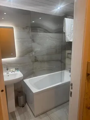 a bathroom with a bath tub and a sink at Glasgow - Cosy 1 Bedroom Apartment in Glasgow