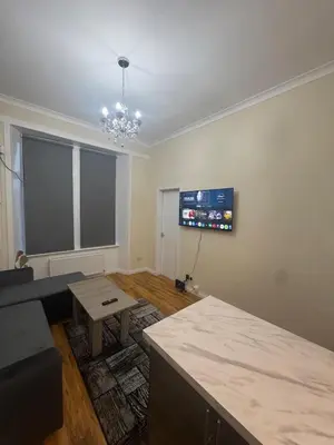 a living room with a couch and a flat screen tv at Glasgow - Cosy 1 Bedroom Apartment in Glasgow